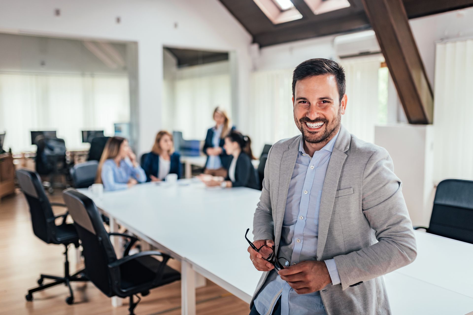 A person standing in front of a table with people sitting at it

Description automatically generated with medium confidence