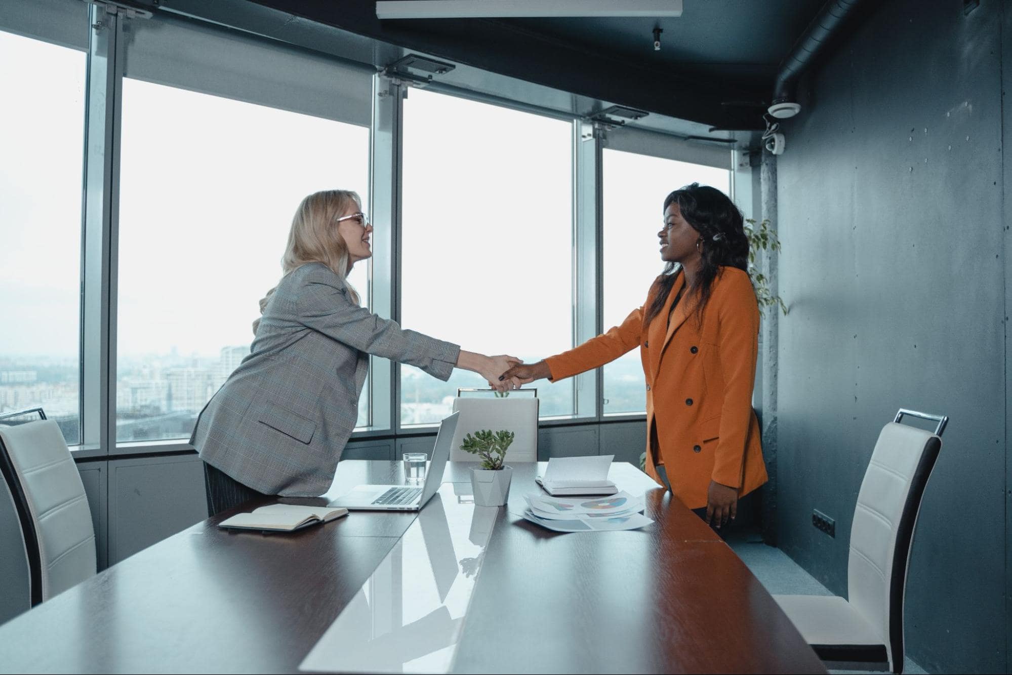 Two women shaking hands in an office