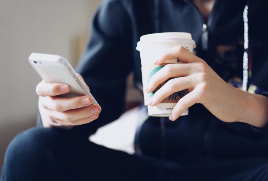 Hand holding Starbucks cup