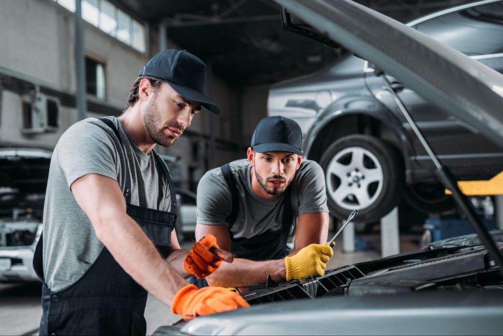 Men repairing engine as automotive franchise