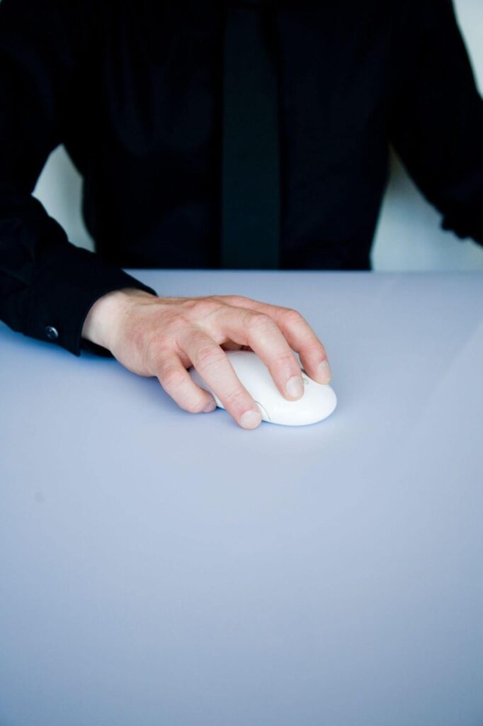 A hand moving a computer mouse A hand moving a computer mouse