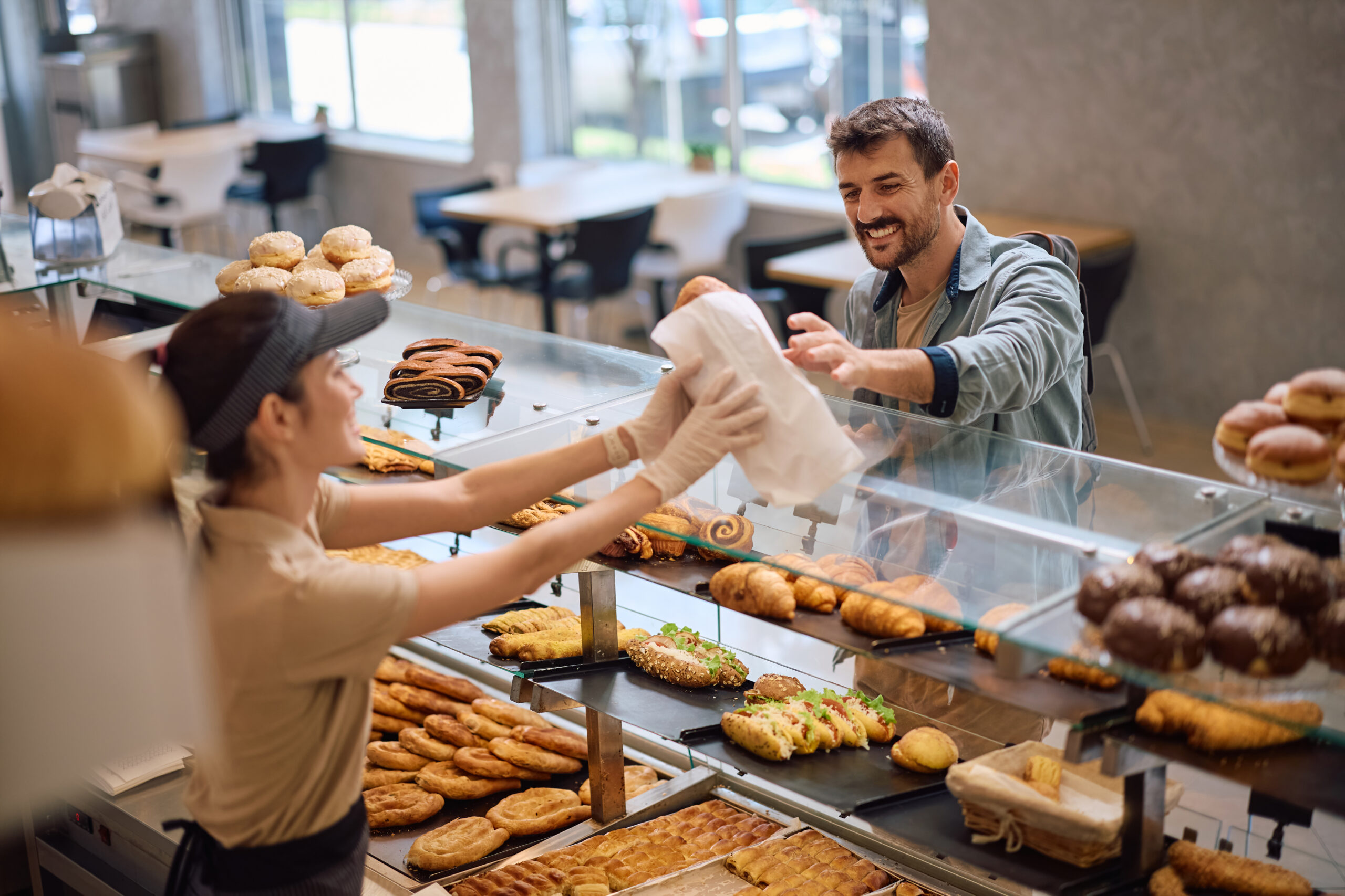 Happy man buying pastry in a bakery